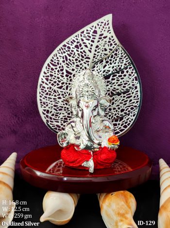 Lord Ganesh Idol with Peepal Leaf Backdrop Silver Plated Murti on Wooden Base Holding Modak and Blessing Hand